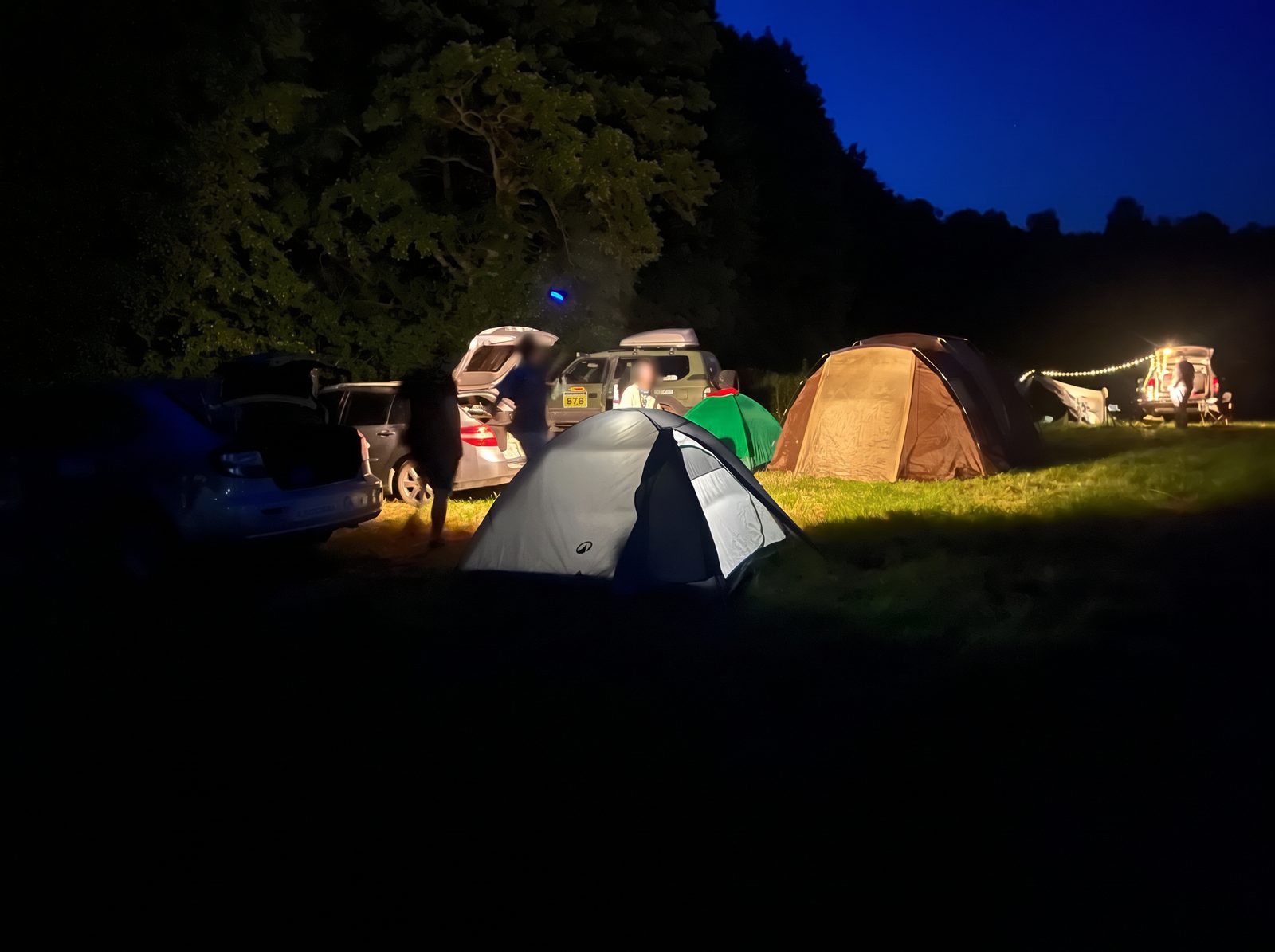 Campsite at night — tents and string lights